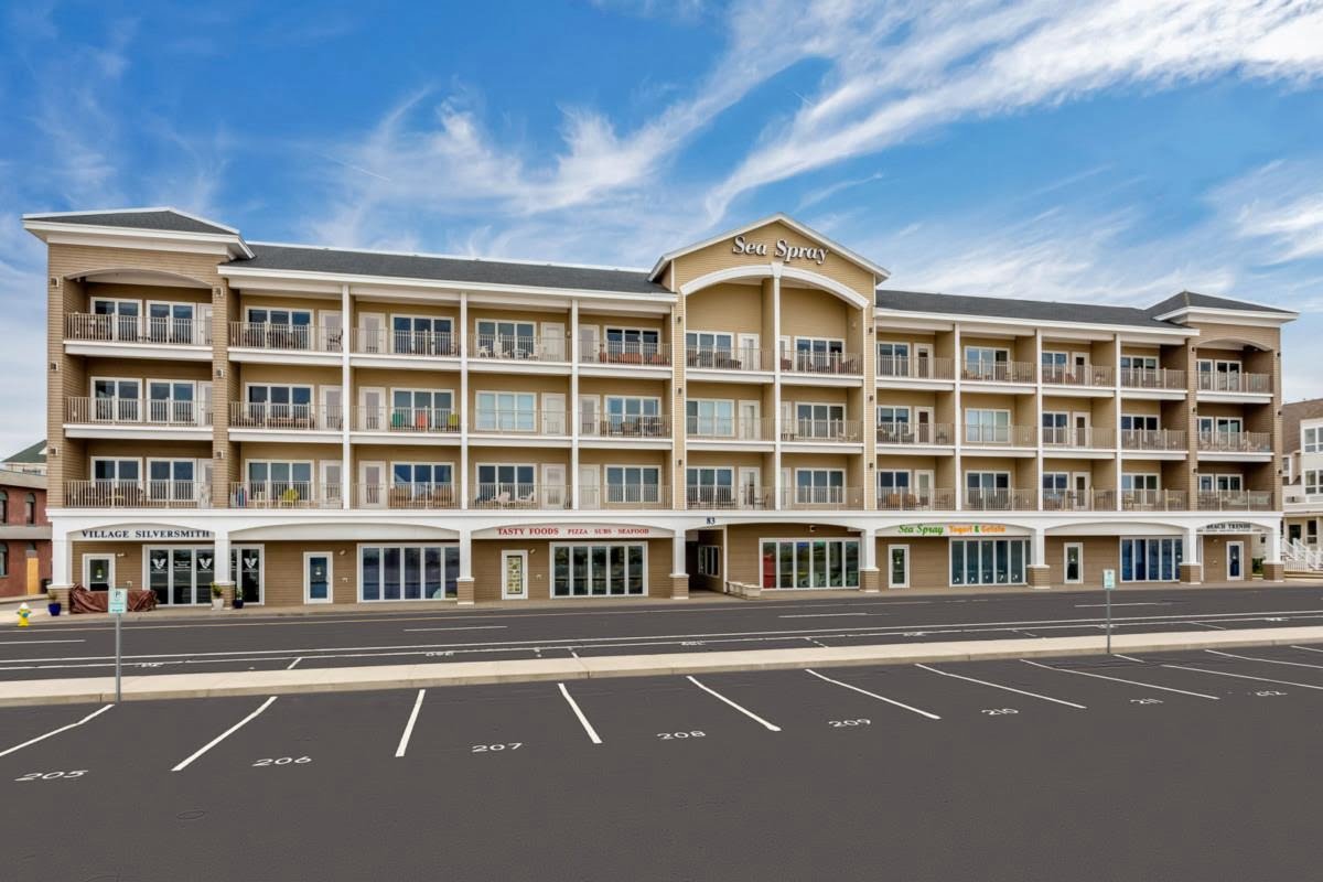 a large hotel with a parking lot in front of it.