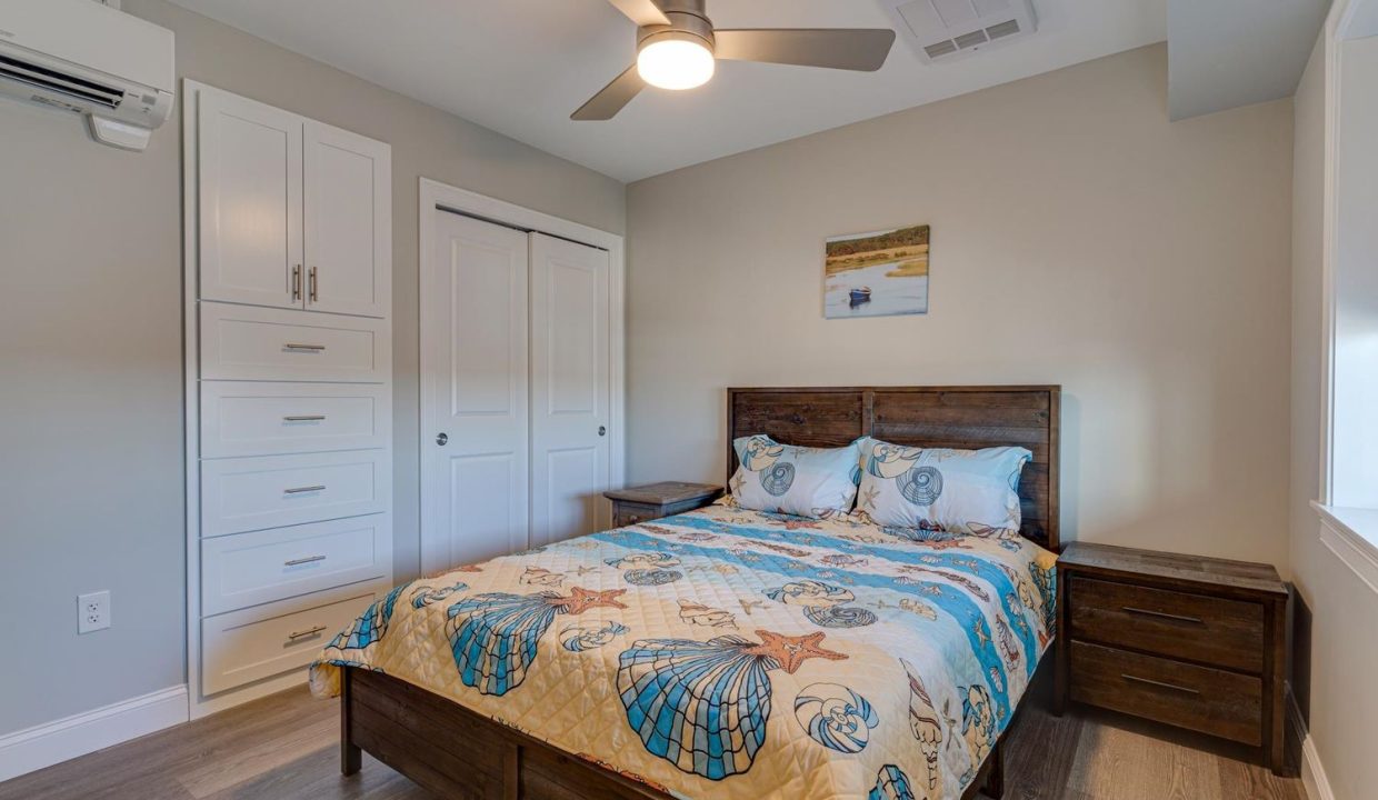 a bedroom with a bed and a ceiling fan.