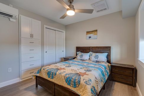 a bedroom with a bed and a ceiling fan.