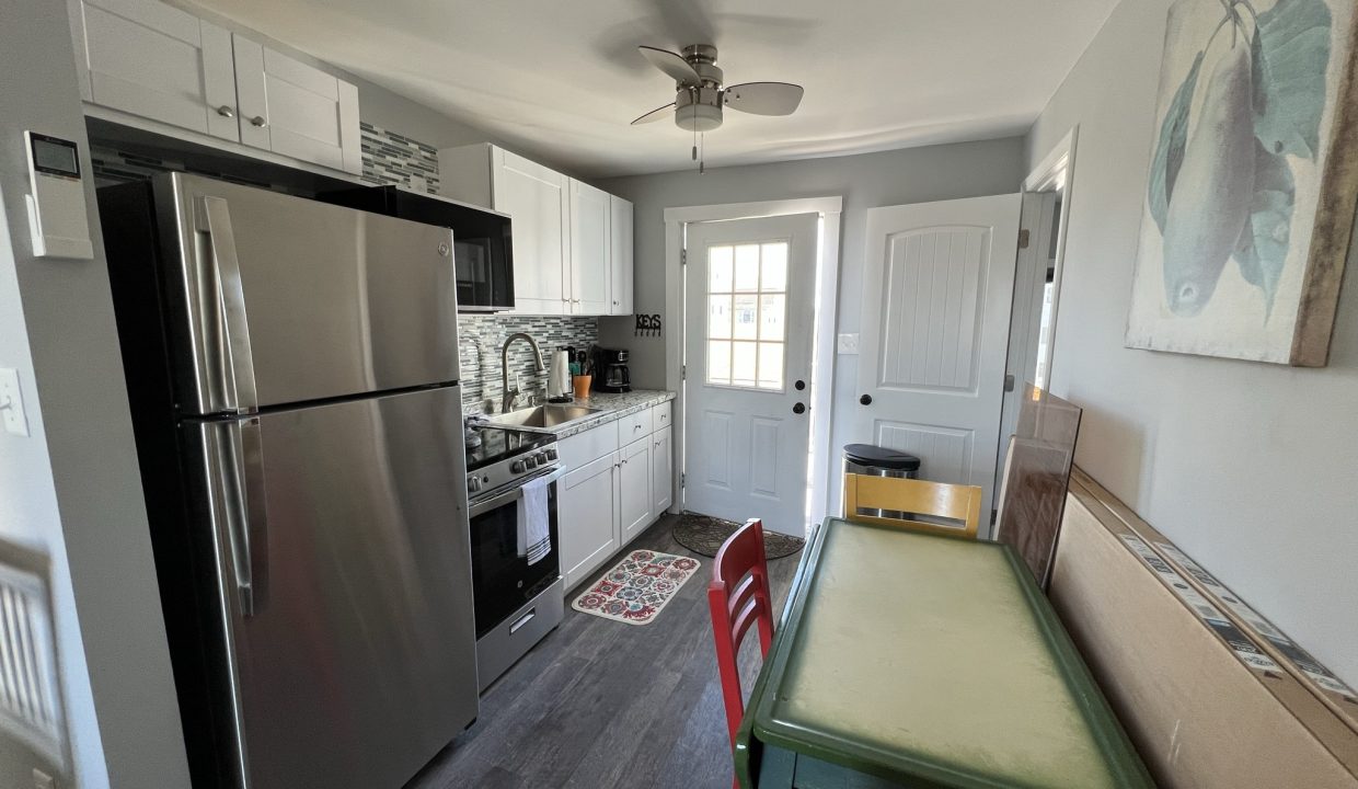 a kitchen with a table and a refrigerator.