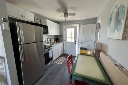 a kitchen with a table and a refrigerator.
