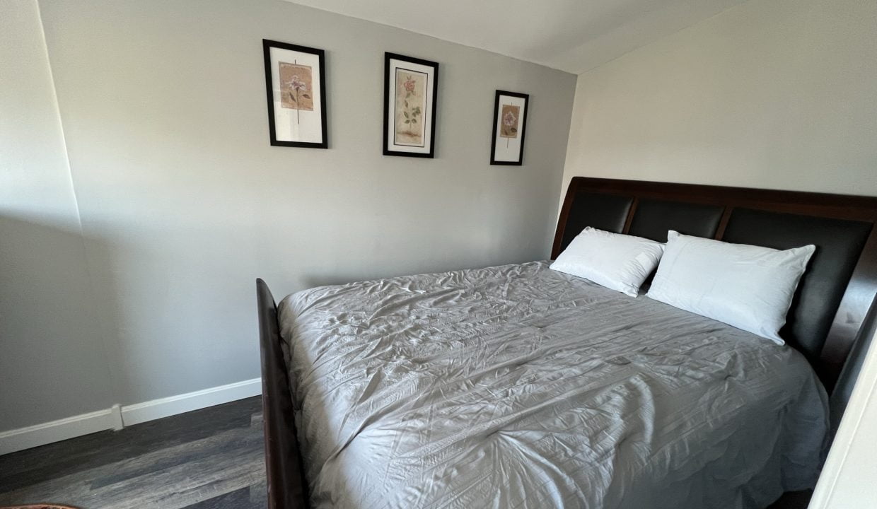 a bedroom with a bed and pictures on the wall.
