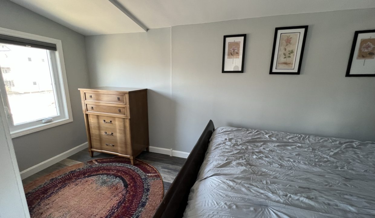 a bedroom with a bed and a dresser.