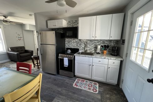 a kitchen with white cabinets and a black stove top oven.