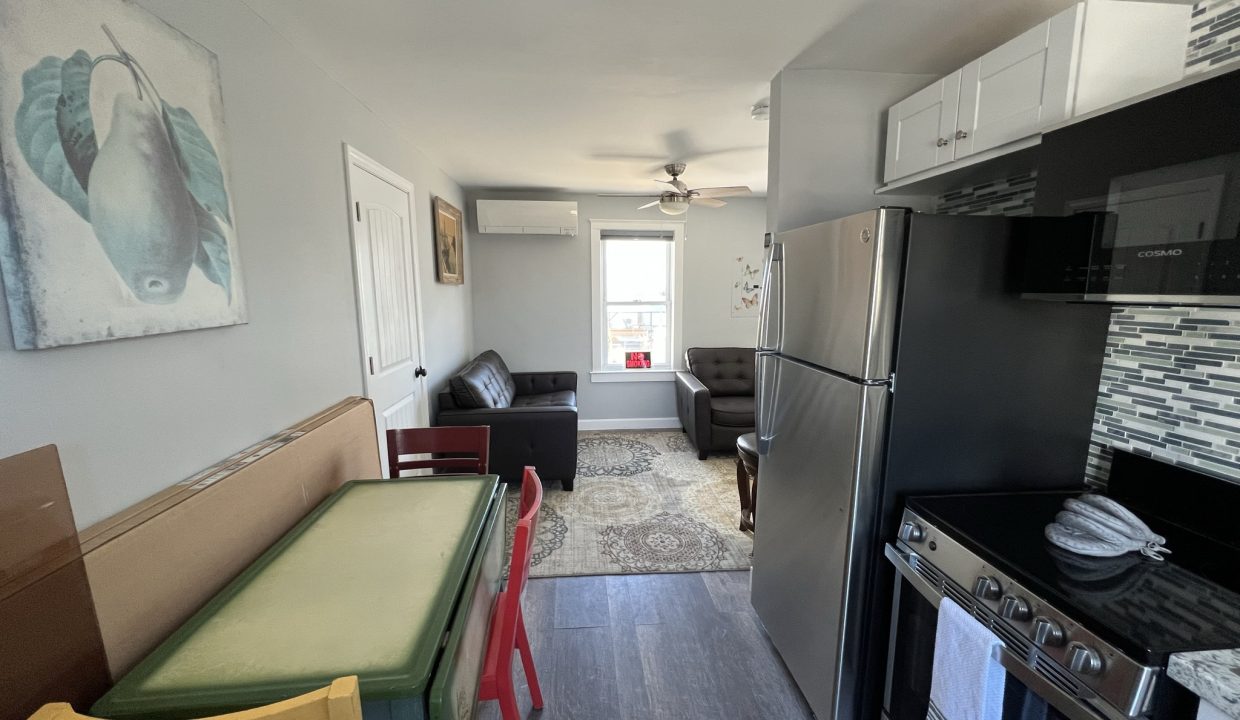 a kitchen with a refrigerator, stove, table and chairs.