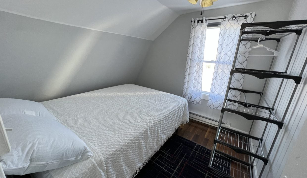 a bedroom with a bed and a ceiling fan.