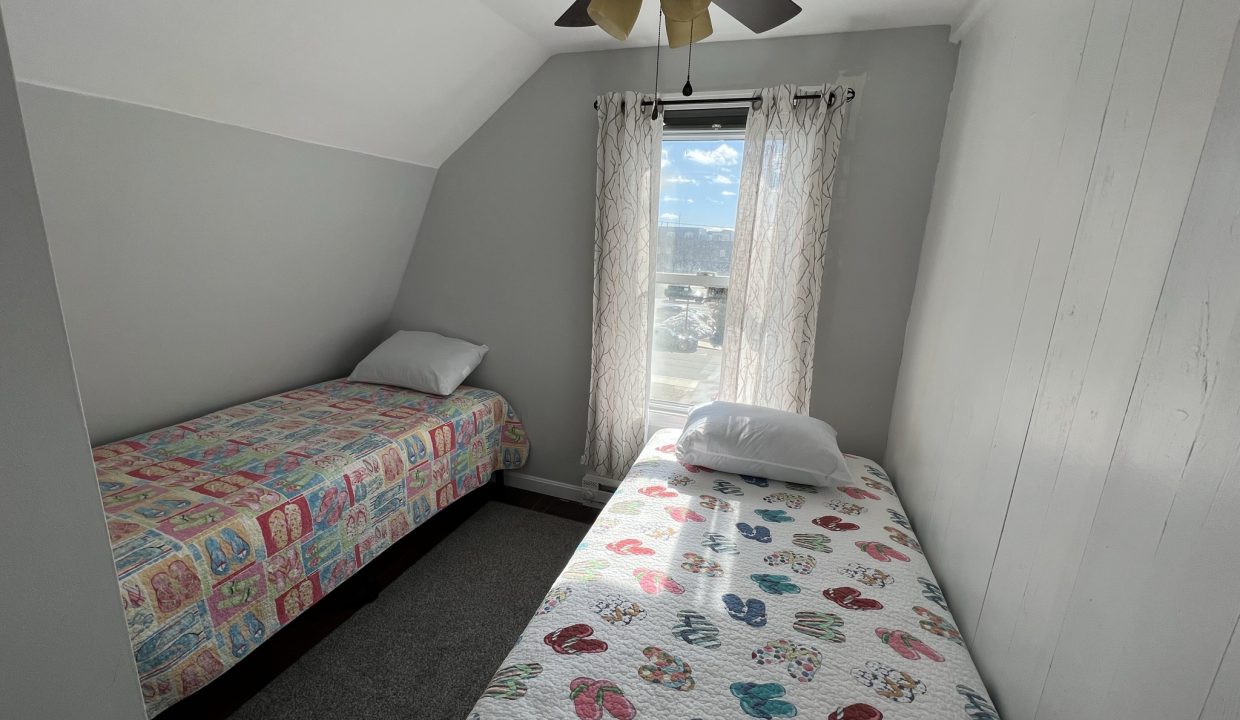 a bedroom with two beds and a ceiling fan.