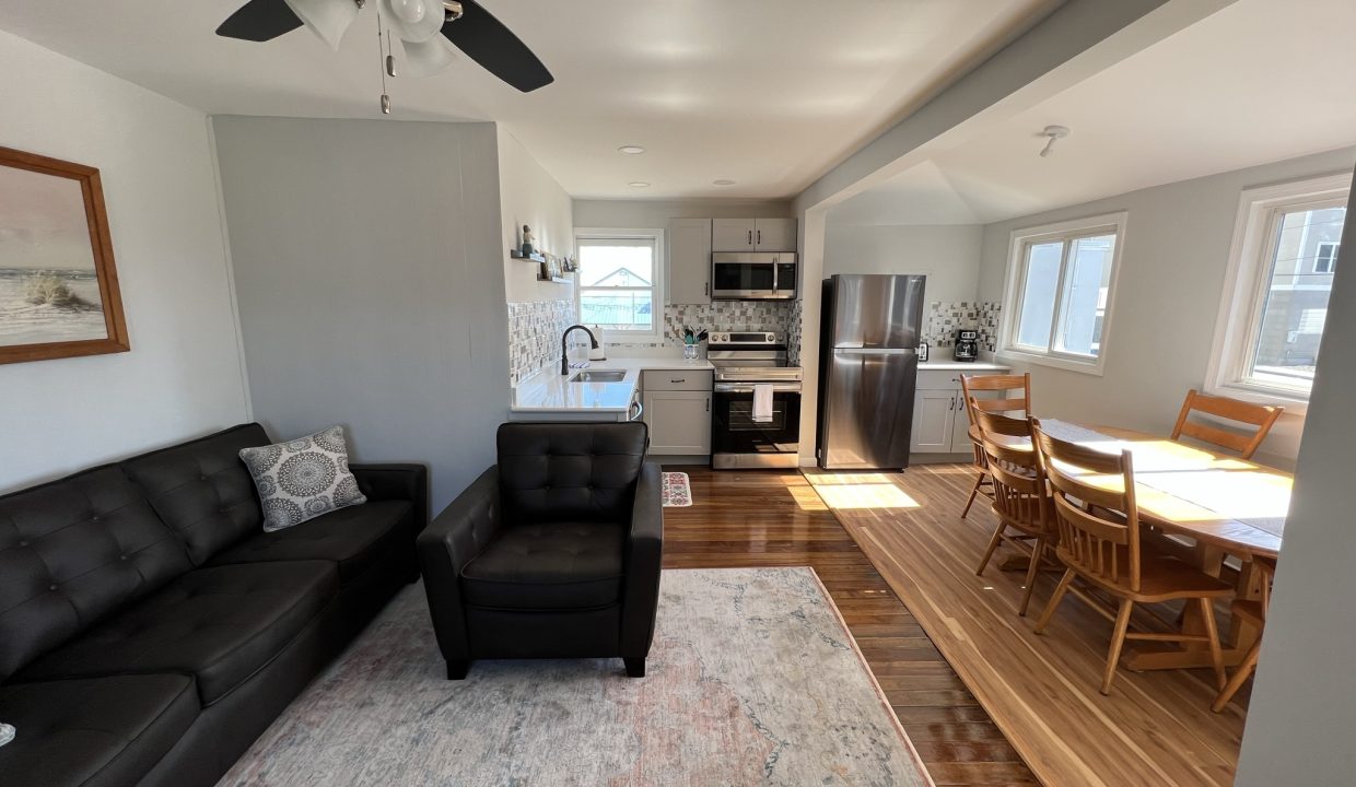 a living room filled with furniture and a ceiling fan.