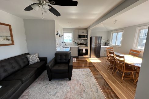 a living room filled with furniture and a ceiling fan.