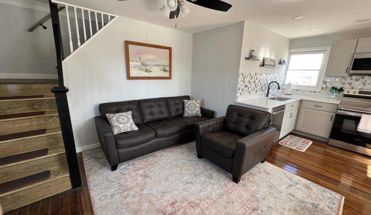 a living room filled with furniture and a ceiling fan.