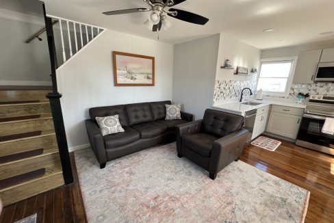 a living room filled with furniture and a ceiling fan.