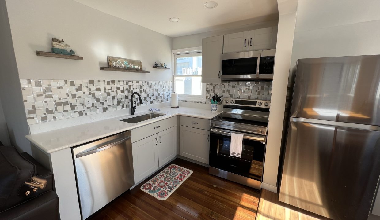 a kitchen with stainless steel appliances and wood floors.