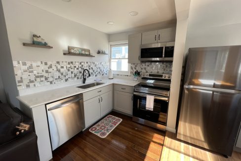 a kitchen with stainless steel appliances and wood floors.