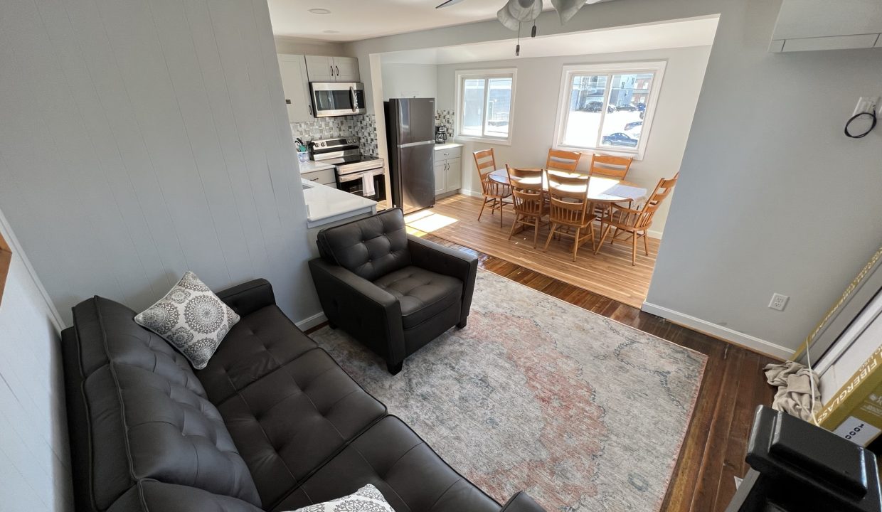 a living room filled with furniture and a ceiling fan.