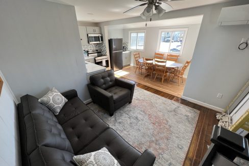 a living room filled with furniture and a ceiling fan.