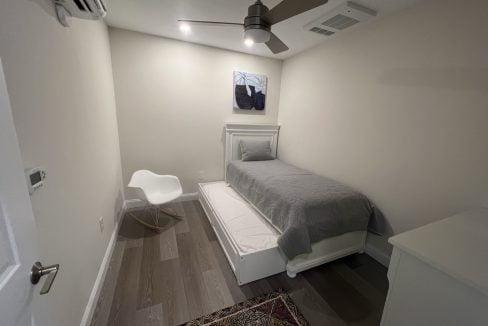 a bedroom with a bed and a ceiling fan.