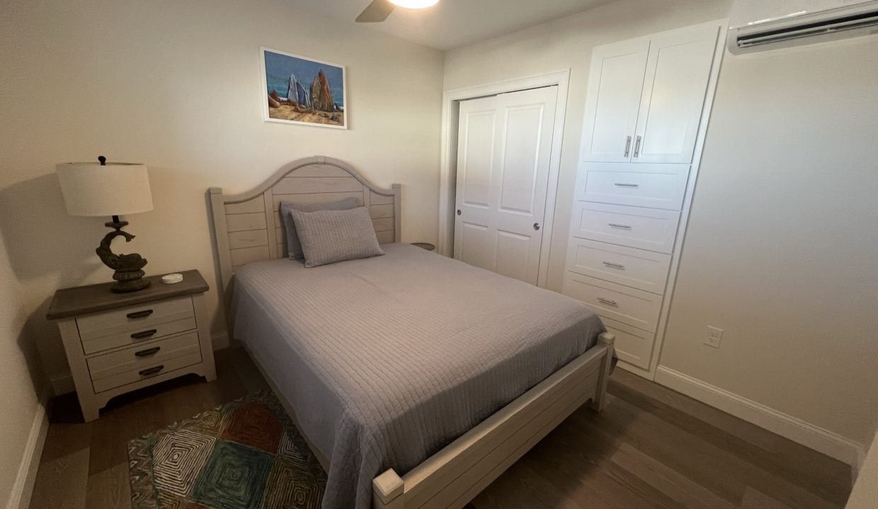 a bedroom with a bed and a ceiling fan.