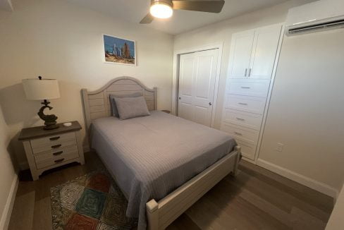 a bedroom with a bed and a ceiling fan.