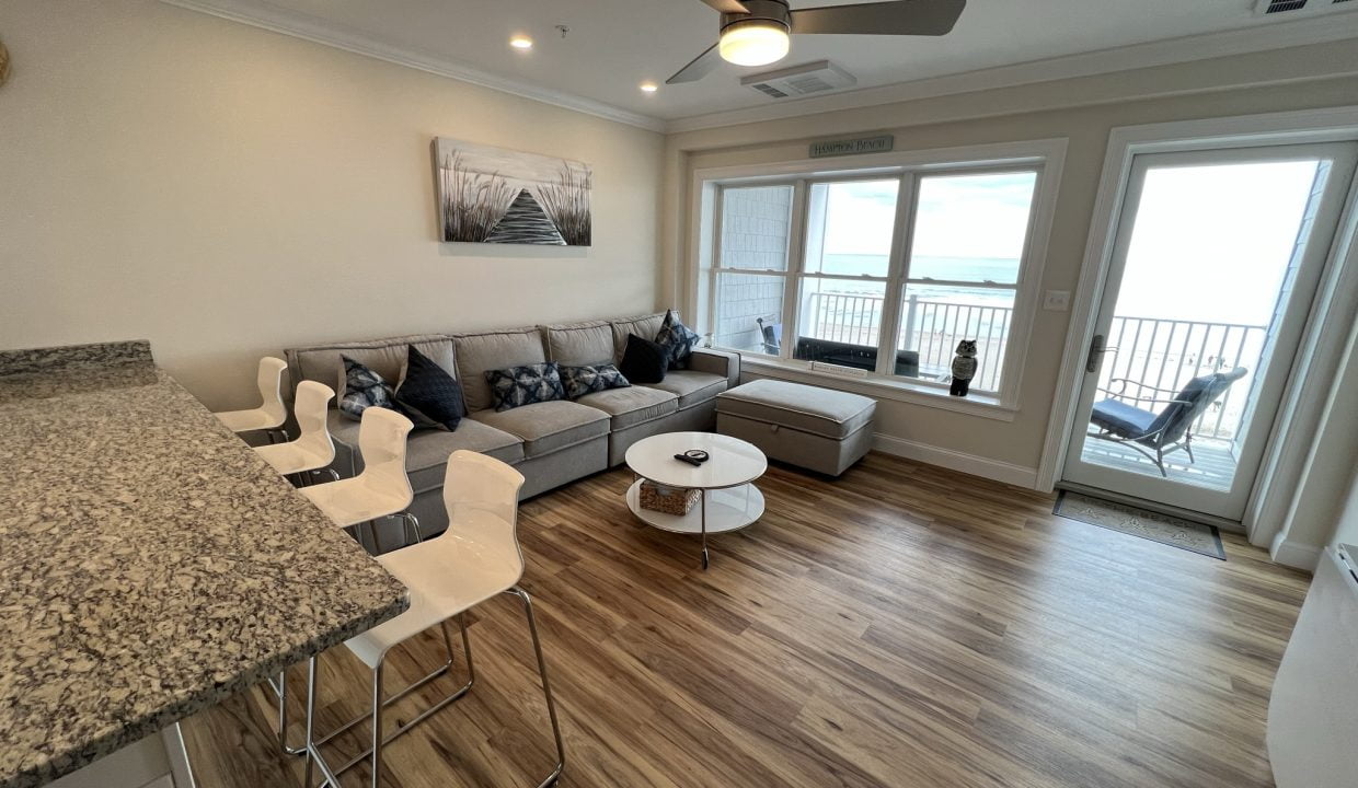 a living room filled with furniture and a large window.