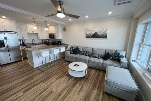 a living room filled with furniture and a kitchen.