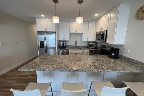 a kitchen with a center island with four chairs.