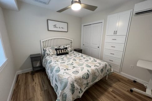 a bedroom with a bed and a ceiling fan.