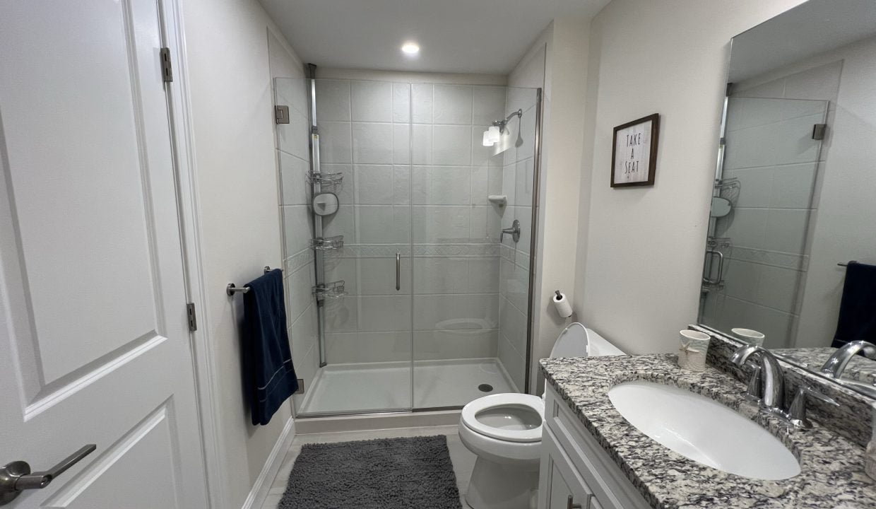 a bathroom with a sink, toilet, and shower.