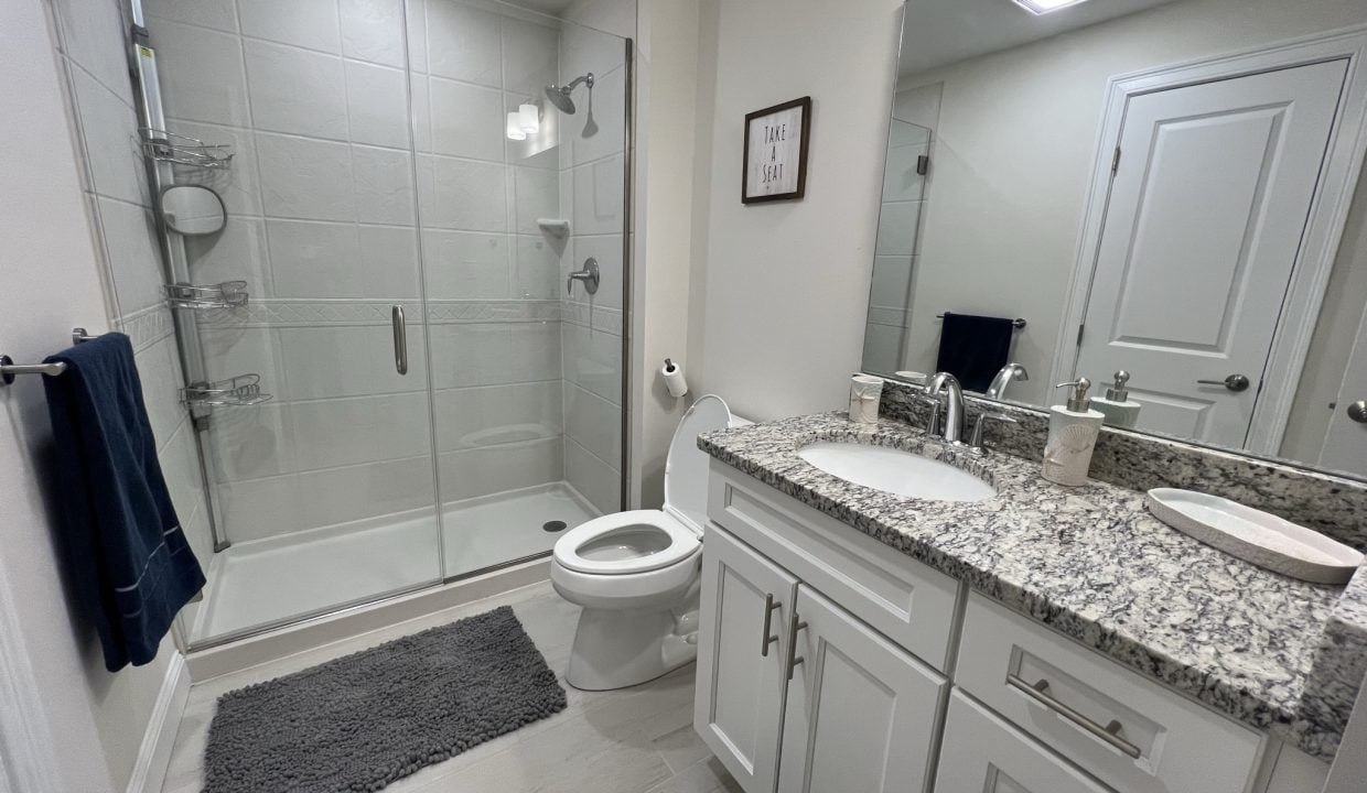 a bathroom with a sink, toilet, and shower.