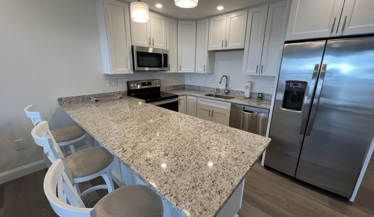 a kitchen with white cabinets and a granite counter top.