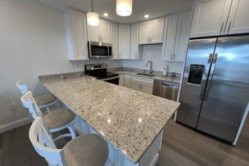 a kitchen with white cabinets and a granite counter top.
