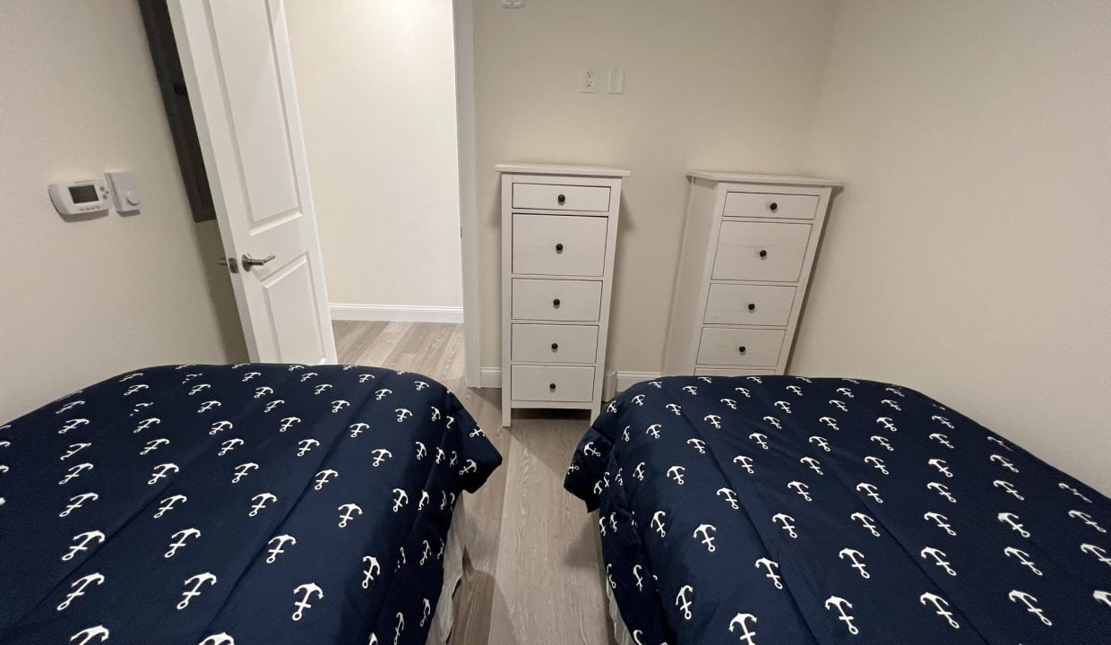 a bedroom with two beds and a dresser.