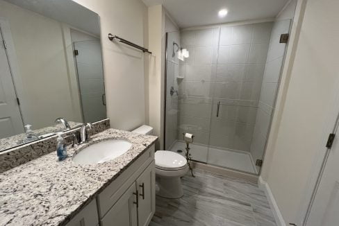 a bathroom with a sink, toilet, and shower.