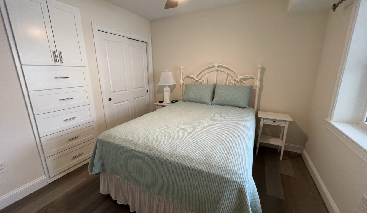 a bedroom with a bed and a ceiling fan.