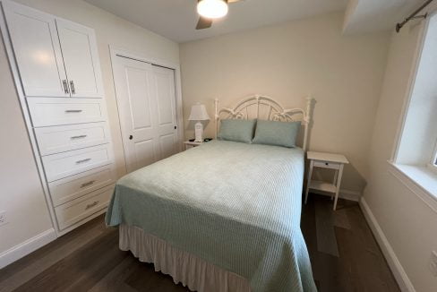 a bedroom with a bed and a ceiling fan.