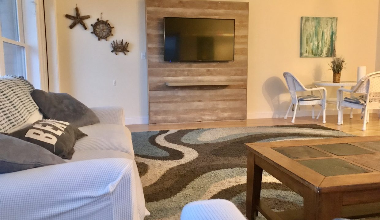 a living room filled with furniture and a flat screen tv.