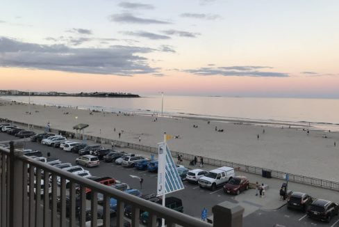 A view of the beach from a balcony at dusk.