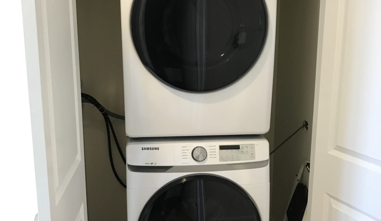 Stacked washer and dryer in a closet.