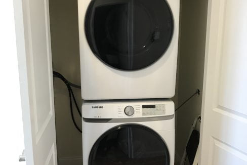 Stacked washer and dryer in a closet.