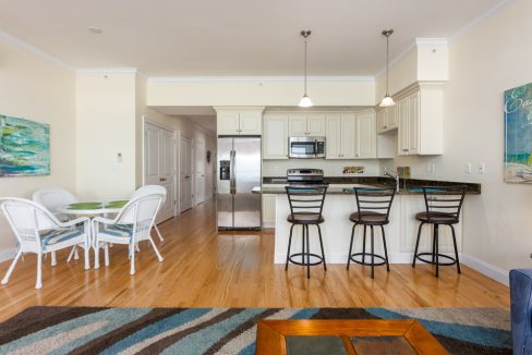 a kitchen with a table, chairs and a refrigerator.