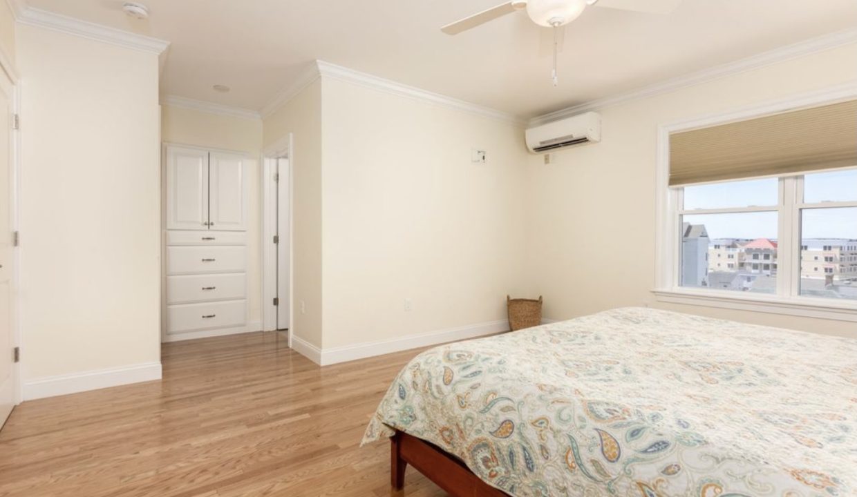 a bedroom with a bed and a ceiling fan.
