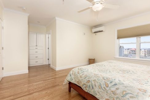 a bedroom with a bed and a ceiling fan.