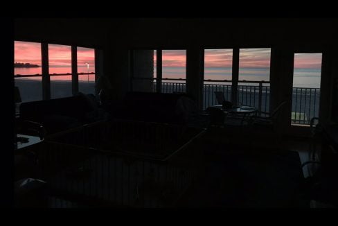 a living room filled with furniture and a view of the ocean.