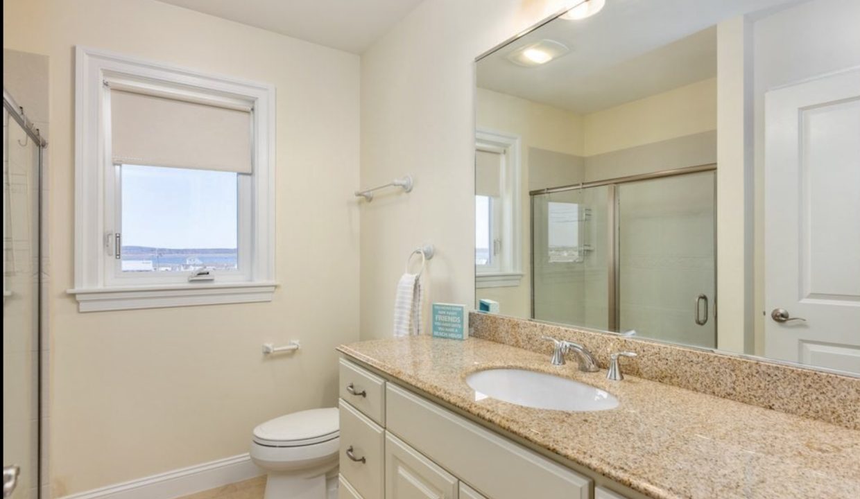 a bathroom with a sink, toilet, and shower.