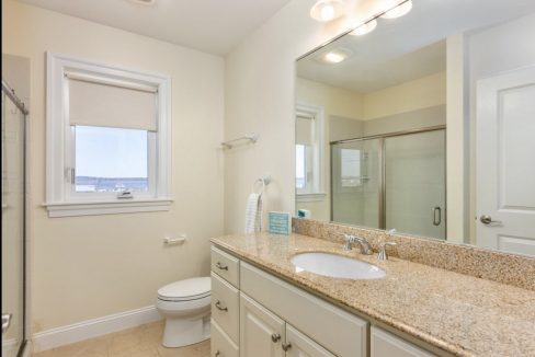 a bathroom with a sink, toilet, and shower.