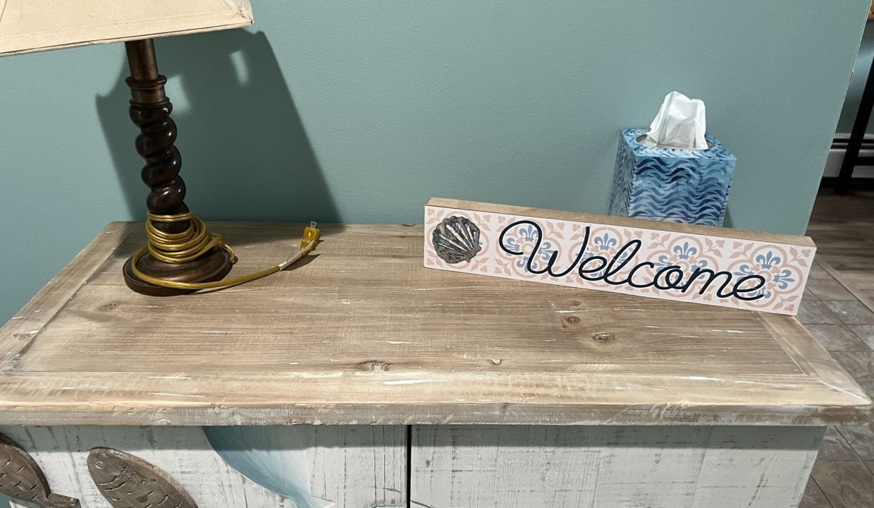 a welcome sign sitting on top of a dresser.