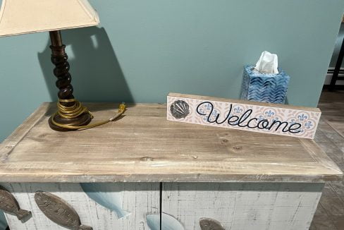 a welcome sign sitting on top of a dresser.