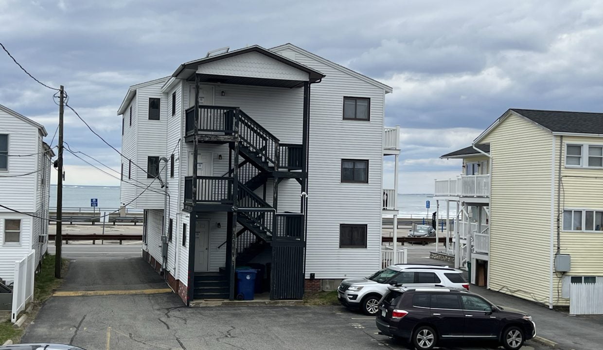 two cars parked in a parking lot next to a building.