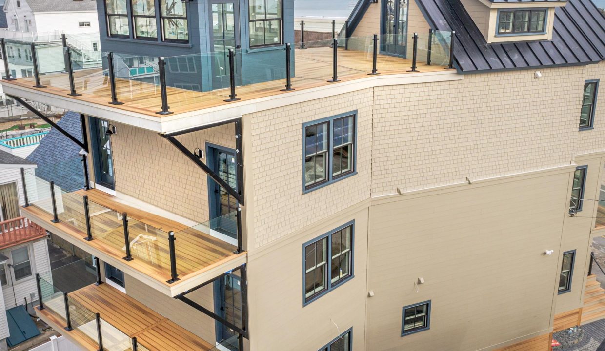 a three story house with a deck and a balcony.