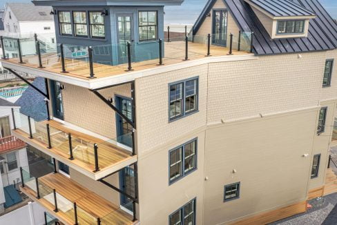 a three story house with a deck and a balcony.