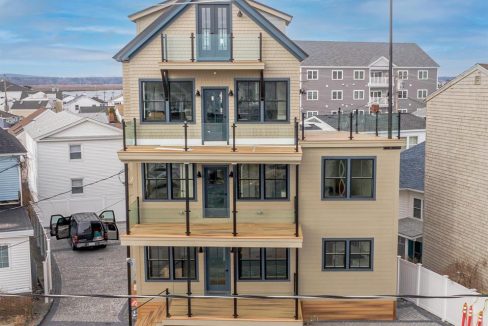 a two story house with a lot of windows and balconies.